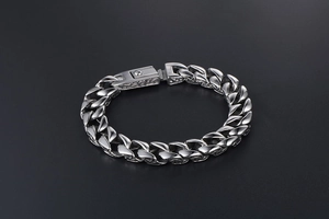 Macro detail of silver titanium steel curb chain bracelet with vintage pattern clasp