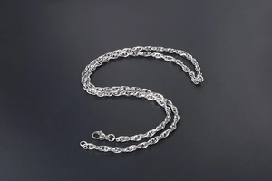 Détail d'un collier chaîne torsadée argentée avec un fermoir mousqueton robuste