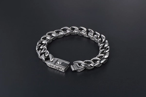 Close-up of titanium steel Cuban link bracelet with diamond box clasp and metallic texture