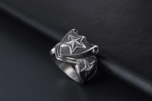 Detailed close-up of retro silver stainless steel shield ring with punk star patterns