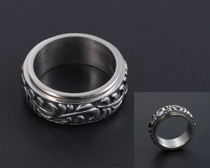 Détail macro d'une bague rotative vintage en acier avec des motifs floraux sculptés