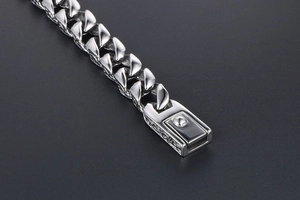 Detailed macro view of silver Cuban link bracelet with engraved hollow box clasp pattern