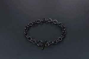 Detail shot of black stainless steel chain bracelet featuring a chunky OT toggle clasp