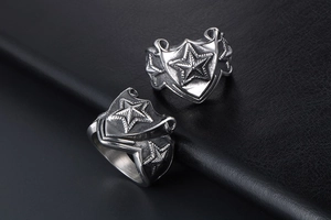 Close-up of vintage silver steel rings with 3D star shields on black leather texture