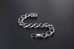 Close-up of polished silver titanium steel cuban chain bracelet with lobster clasp