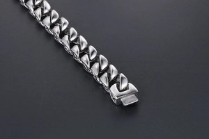 Macro view of polished titanium steel curb chain link bracelet with secure plug-in clasp
