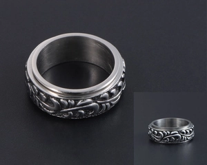Détail d'une bague rotative vintage en acier inoxydable avec gravure de vignes florales