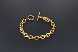 Detailed close-up of golden stainless steel chain bracelet with stylish OT toggle clasp