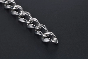 Macro shot of silver-colored thick Cuban chain links with high-polished metal finish