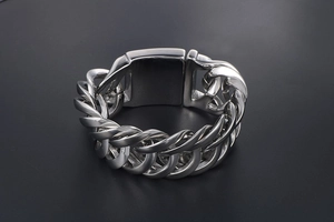 Nahaufnahme eines schweren Edelstahl-Panzerarmbands für Herren mit poliertem Breitverschluss