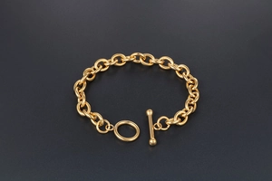 Detail of gold titanium steel bracelet featuring a thick link chain and toggle clasp