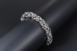 Macro detail of silver woven Byzantine style stainless steel chain bracelet on display