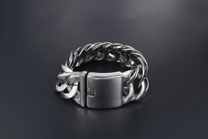 Nahaufnahme von poliertem, breitem Edelstahl-Panzerarmband mit sicherem Kastenverschluss