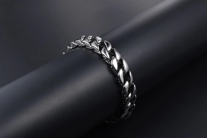 Close-up of polished silver titanium steel Cuban link bracelet on a dark background