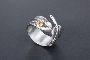 Macro detail of vintage feather ring with oxidized finish and golden emblem