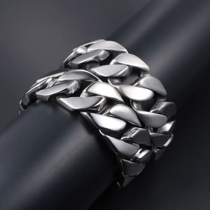Bracelet à mailles cubaines en acier titane poli sur un support cylindrique noir