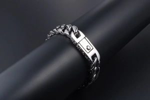 Macro shot of silver titanium steel Cuban chain bracelet with a square clasp mechanism