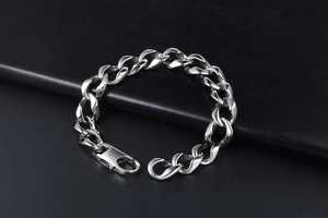 Close-up of a silver titanium steel Cuban link bracelet with a lobster clasp closure