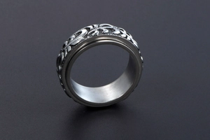 Vue macro d'une bague rotative argentée avec motifs gravés et bande intérieure polie