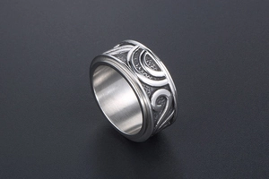 Dettaglio di anello rotante vintage in argento con motivo floreale a rilievo e acciaio opaco