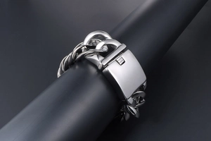 Detailansicht eines breiten, polierten Edelstahl-Panzerarmbands mit einer Metallschnalle