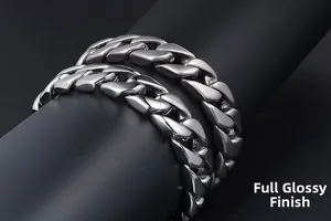 Macro shot of two full polished silver Cuban link chains on a black cylindrical display