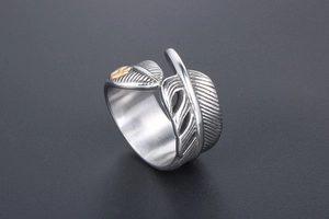 Macro shot of retro feather ring with golden eagle relief and antique silver finish