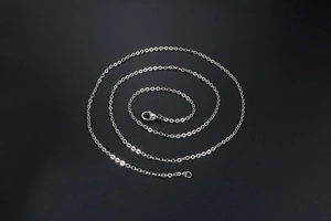 Detailed macro view of a silver titanium steel O-link chain with a secure lobster clasp