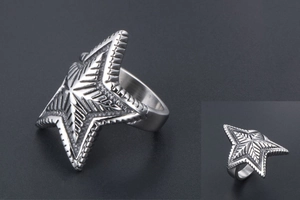 Macro detail of silver star ring featuring intricate radial textures and edgy metal design