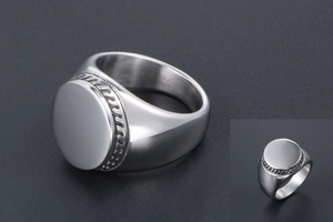 Detailed macro view of silver signet ring with engraved woven texture and polished top surface