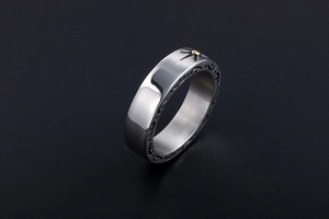 Detail of vintage steel ring with golden sun pattern and engraved tribal textures