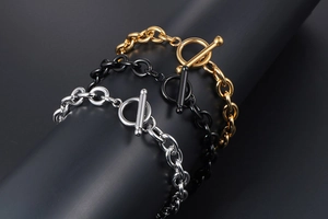 Detailed view of tricolor toggle clasp chain bracelets in gold, silver, and black finish