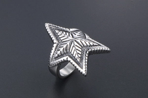 Macro shot of silver pentagram ring with detailed radial engraved texture on metal