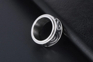 Dettaglio di un anello rotante vintage in argento con motivi a volute industriali a rilievo