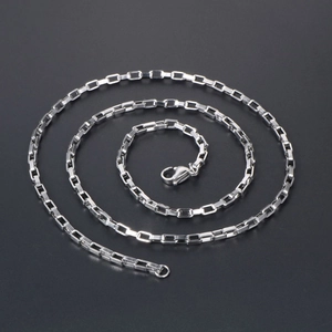 Collier chaîne boîte en acier titane poli avec fermoir mousqueton sur fond gris foncé