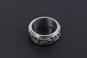 Vue macro d'une bague rotative en acier inoxydable avec motifs de feuilles vintage