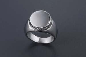 Detail of wide stainless steel signet ring with rope edge and polished round top surface
