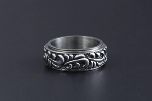 Macro d'une bague rotative en acier inoxydable avec motif floral vintage en relief