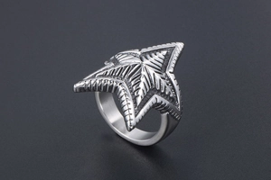 Macro shot of silver pentagram ring featuring 3D radial texture and industrial steel finish