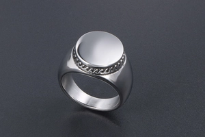 Macro shot of silver signet ring with a smooth circular top and rope-textured edge detailing