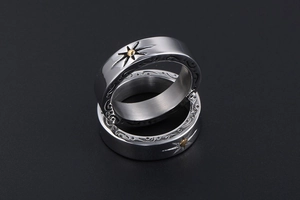 Detail of vintage titanium steel rings with intricate scroll patterns and sun motifs