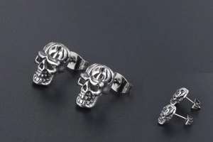 Gros plan de boucles d'oreilles crâne en acier rétro avec finition vintage