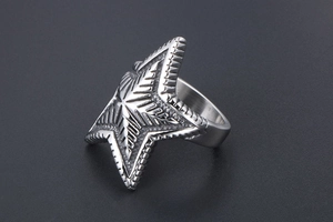 Macro shot of vintage silver star ring with punk radial texture and embossed details