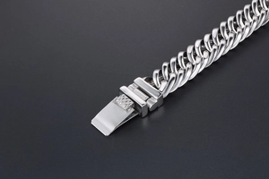 Détail d'un bracelet gourmette en acier inoxydable poli argenté avec fermoir texturé