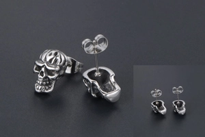 Gros plan de boucles d'oreilles tête de mort rétro avec texture flamme et fermoir papillon