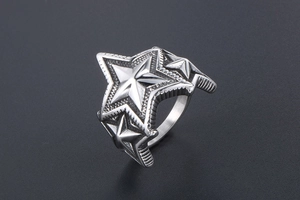 Détail macro d'une bague en acier titane rétro avec trois étoiles en relief 3D oxydées