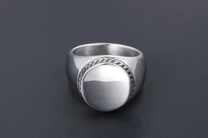 Macro detail of silver titanium signet ring featuring a polished round top and wavy border