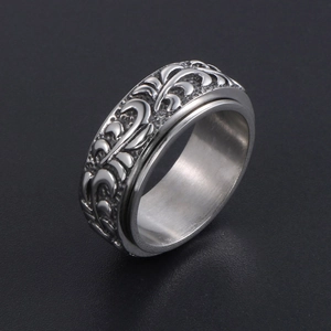 Bague vintage en acier inoxydable avec motifs à volutes en relief sur fond sombre