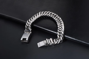 Détail d'un bracelet gourmette double en acier inoxydable avec fermoir carré sur cuir noir