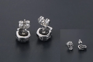 Détail macro de clous d'oreilles crâne en acier titane vintage avec fermoir papillon